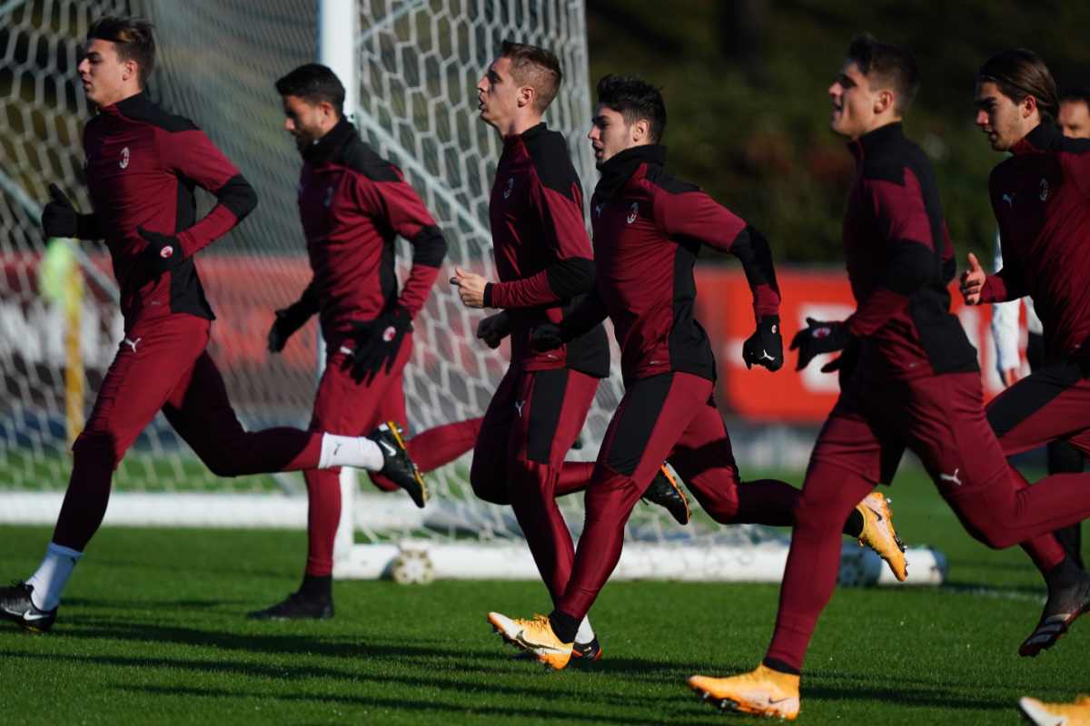 Andrea Conti corre in allenamento a Milanello con altri compagni di squadra