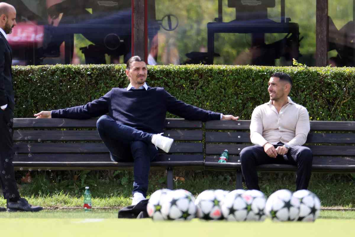 Ibrahimovic e Moncada seduti su una panchina a Milanello mentre guardano un allenamento
