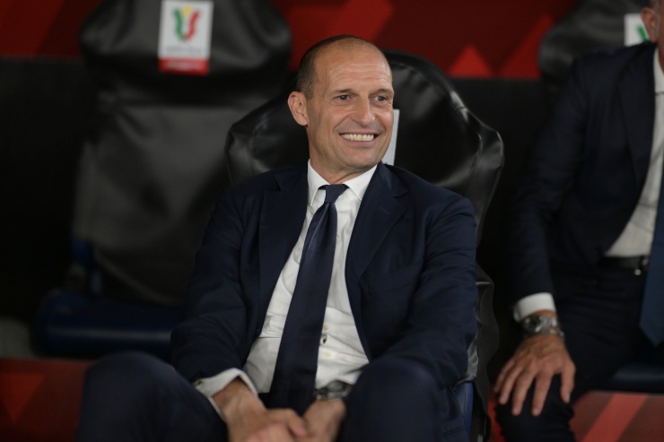 Massimiliano Allegri sorridente e seduto in panchina