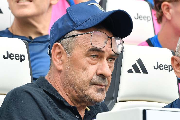 Maurizio Sarri allenatore seduto in panchina mentre guarda una partita