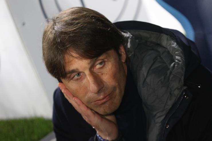 Antonio Conte allenatore del Napoli seduto in panchina con la testa appoggiata alla mano destra