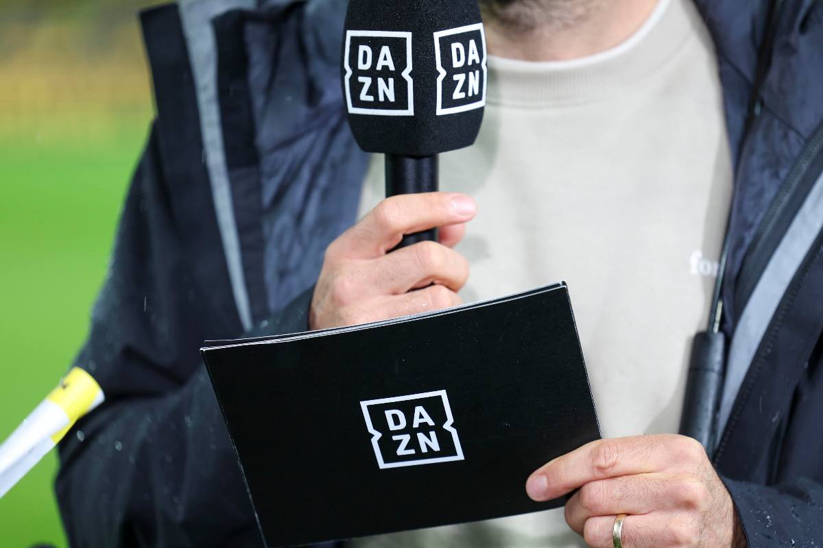 Il microfono con marchio DAZN tenuto in mano da un giornalista