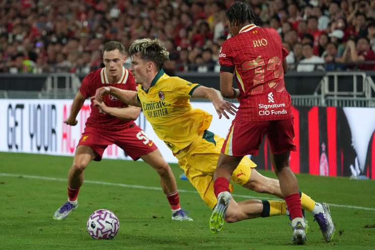 Alexis Saelemaekers calciatore del Milan cade durante un'azione contro il Liverpool