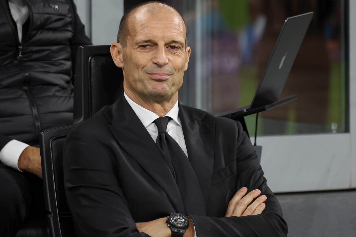 Massimiliano Allegri allenatore del Milan sorride mentre è seduto in panchina a San Siro