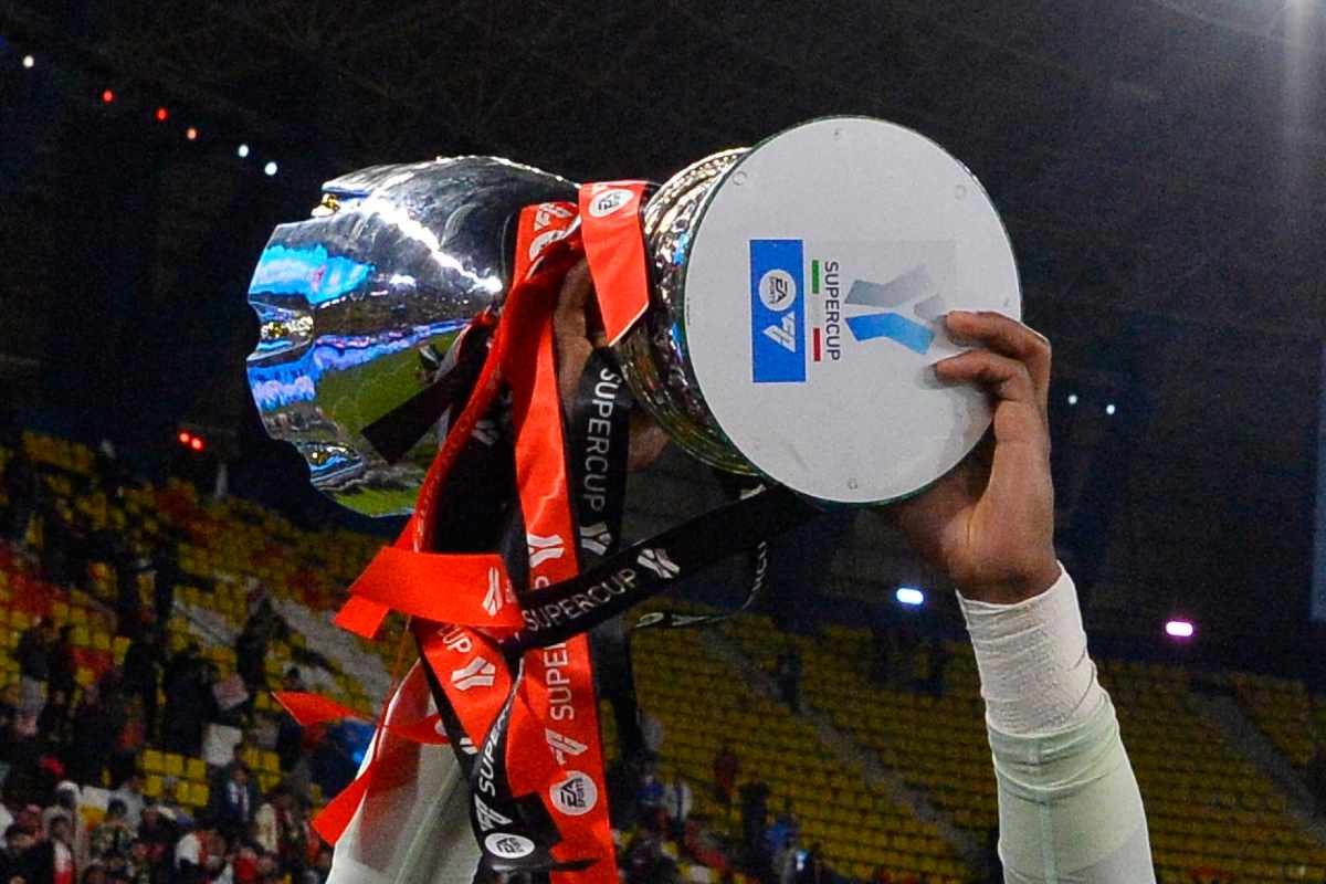 Il trofeo della Supercoppa Italiana alzato verso il cielo da Mike Maignan